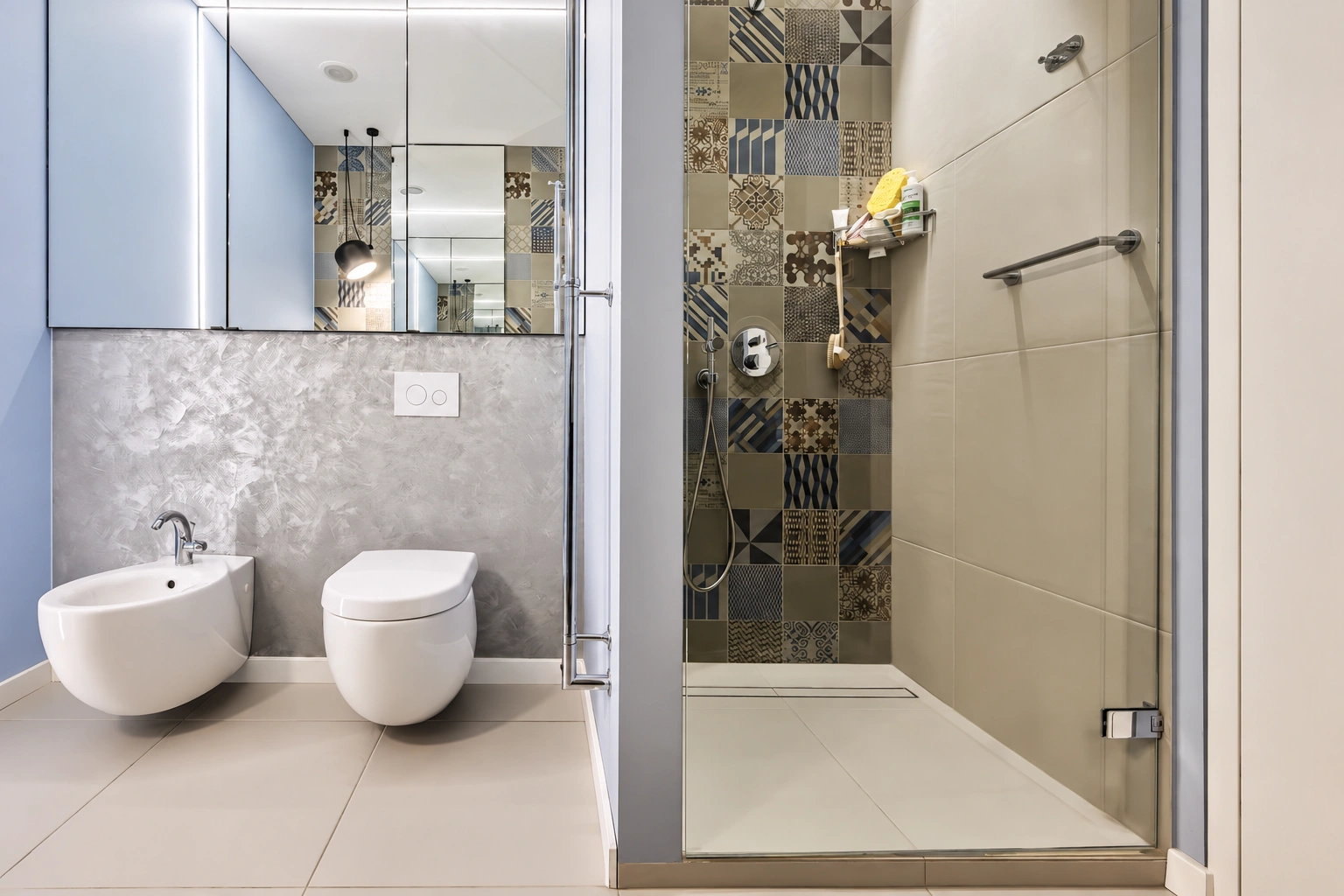 Bathroom with a shower enclosure, a toilet, and a bidet installed next to it.