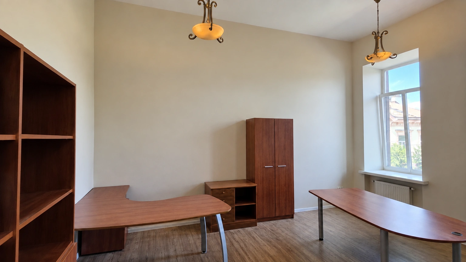 A room with two tables and open shelves along the wall.