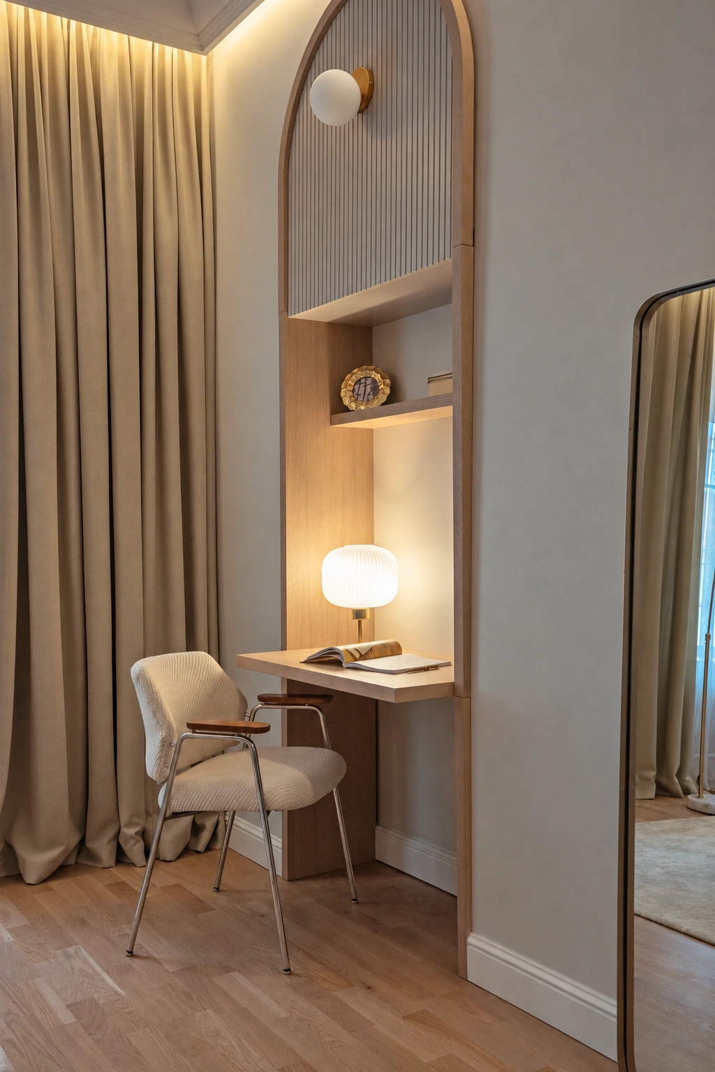 A small table with a table lamp is set up in a wall niche, and a chair is placed in front of it.