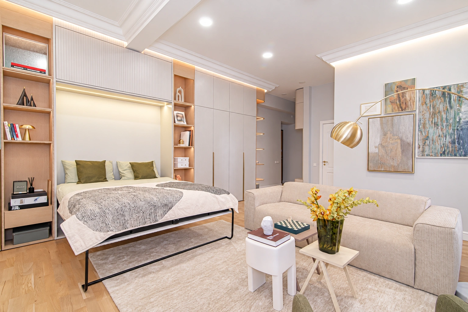 In the room, there is a bed, a light-colored sofa, and a small round table with a flower vase.