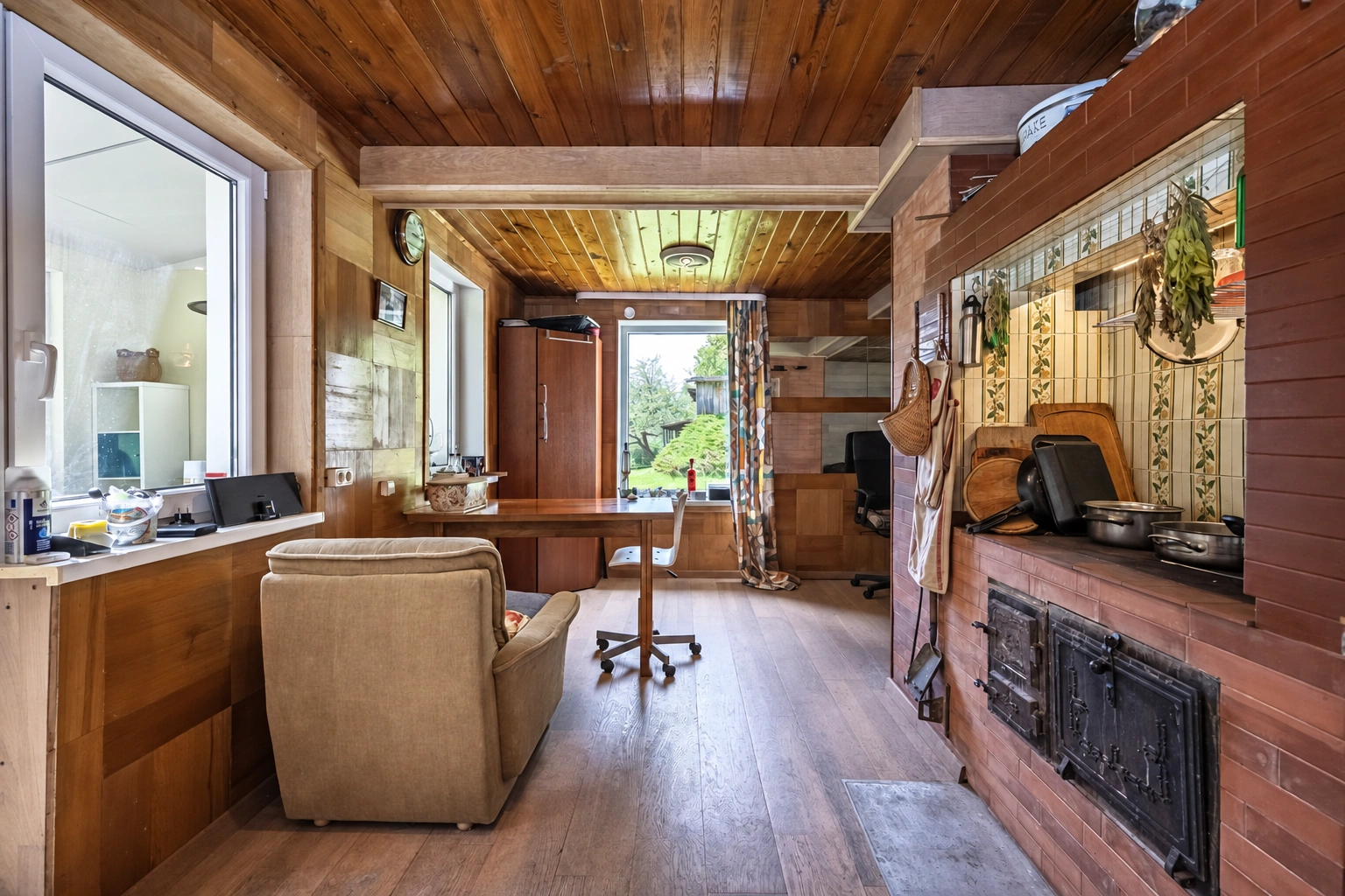 A room with large windows and a stove by the right-hand wall.