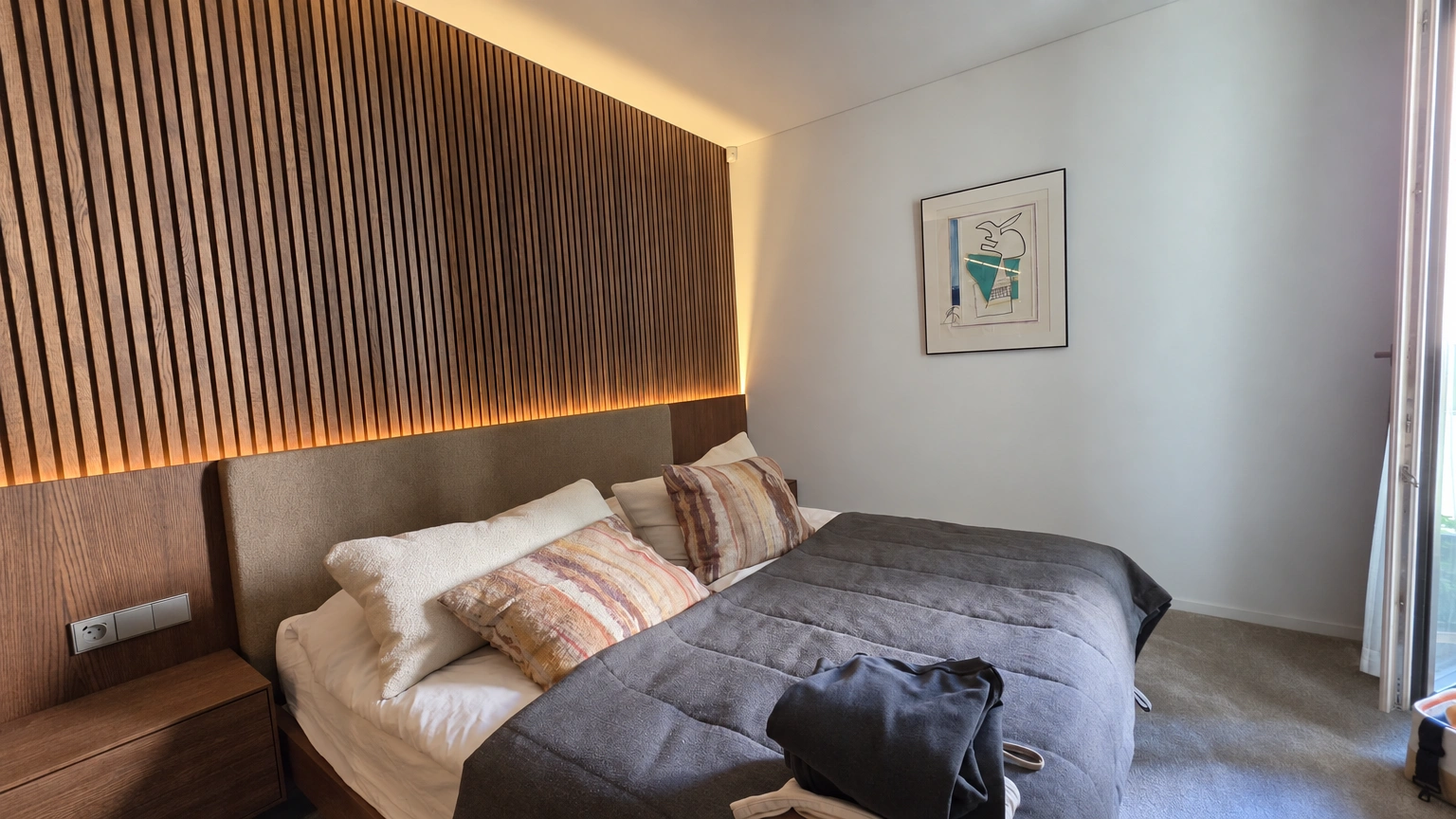 Bedroom with a double bed and illuminated vertical-strip detailing above the headboard.