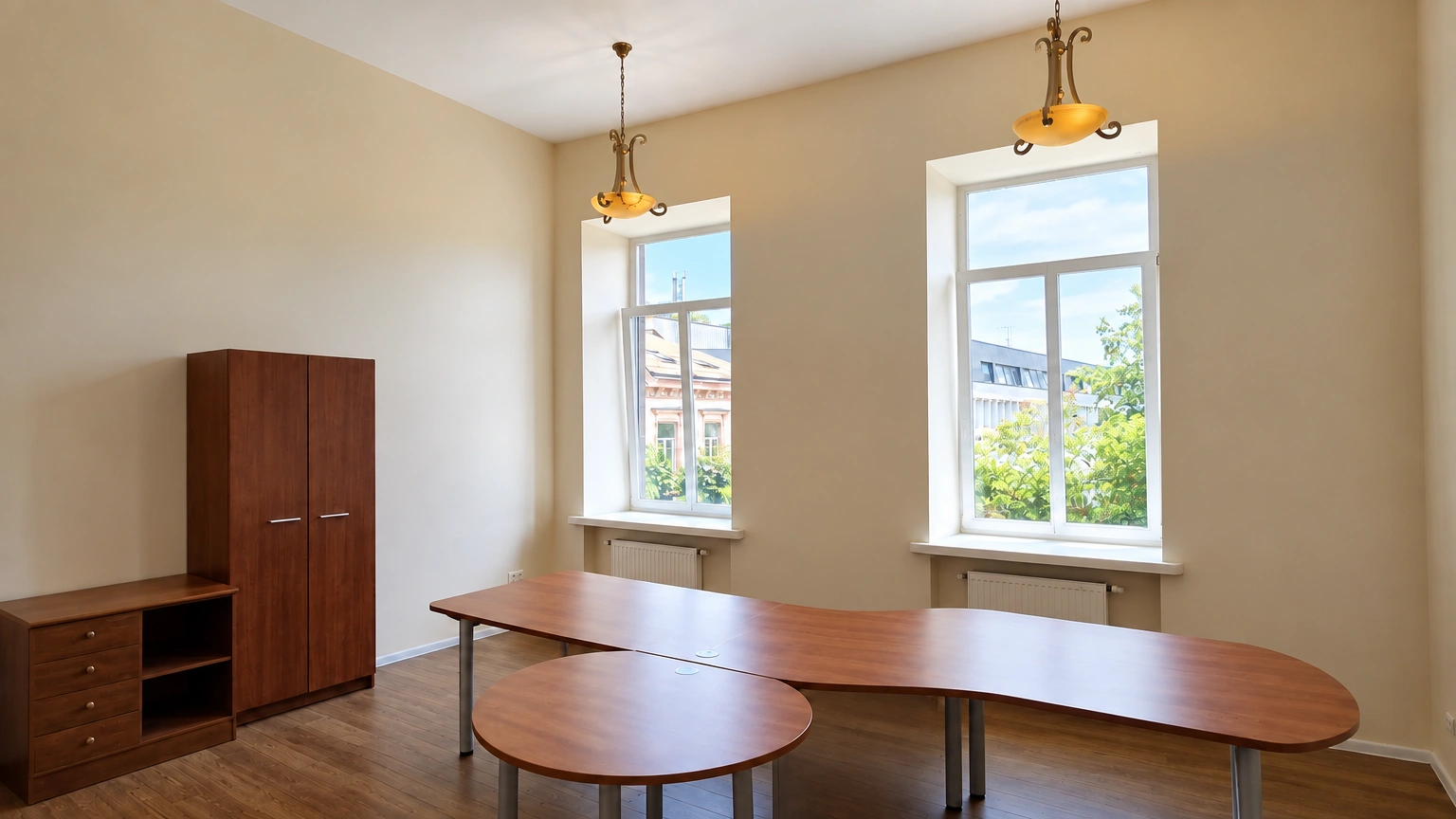 A room with a large desk and two tall windows.