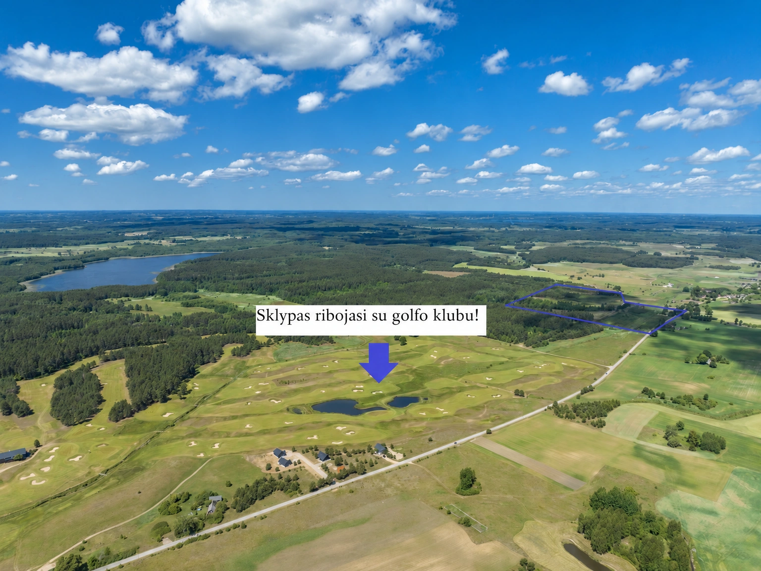 Blick von oben auf ein Gebiet mit Feldern und Wäldern, Gewässern sowie einer Straße, die das Gebiet durchquert.