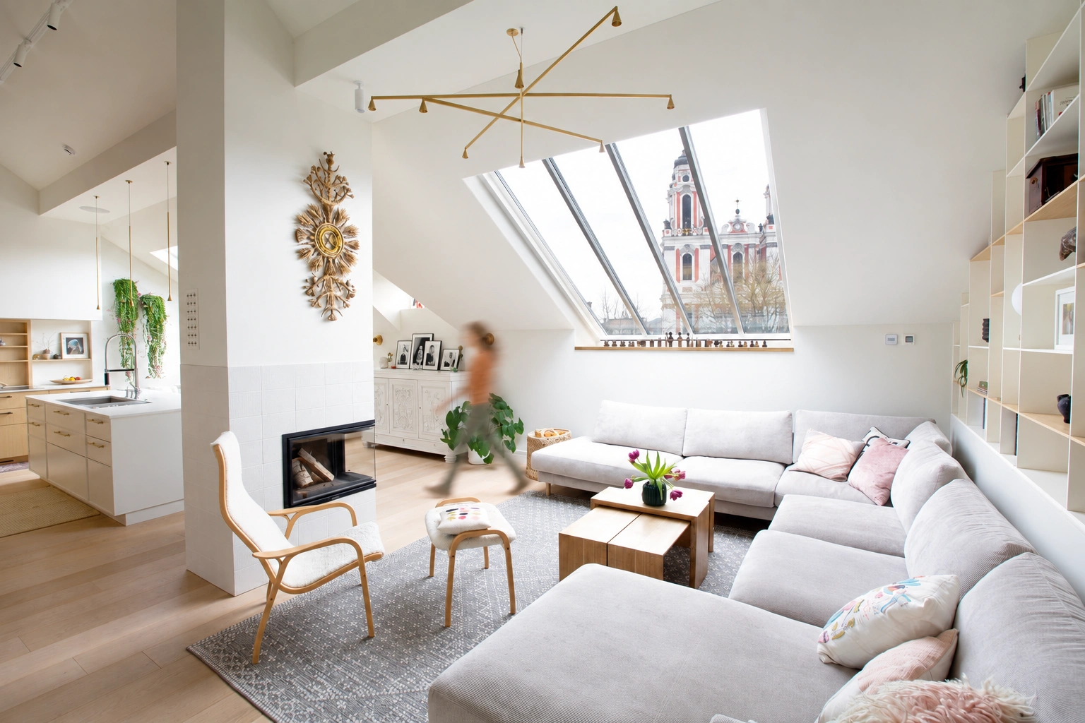 Wohnzimmer mit einem hellen Ecksofa und einem großen Dachfenster.