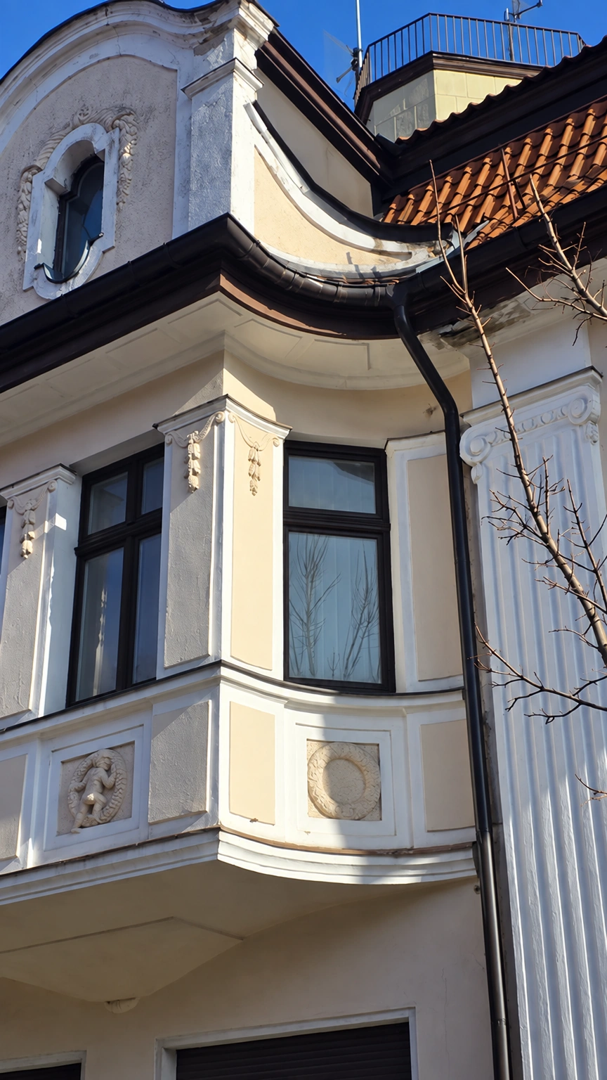 Building facade with a bay window, tall windows, and decorative ornaments.