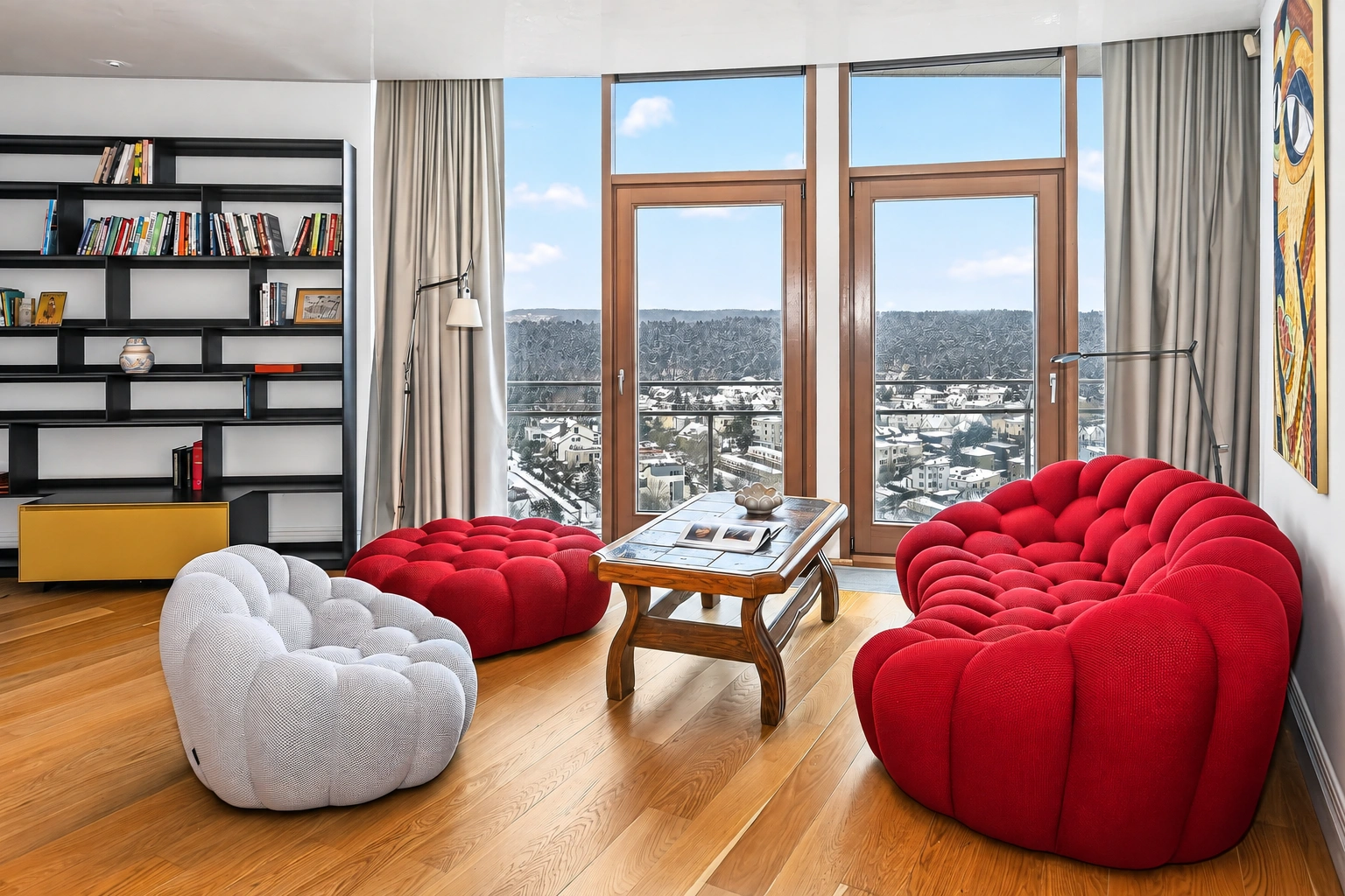 Wohnzimmer mit einem roten Sofa und einem weißen Sessel neben großen Fenstern.