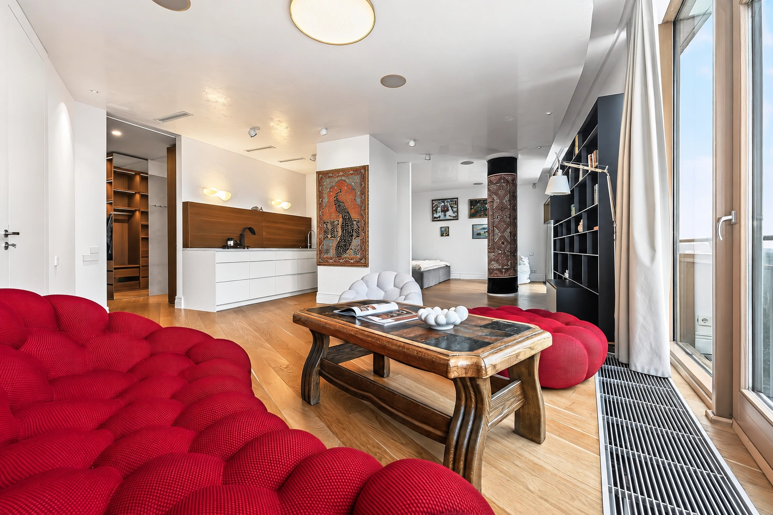 Wohnzimmer mit roten Sofas und einem Couchtisch aus Glas.
