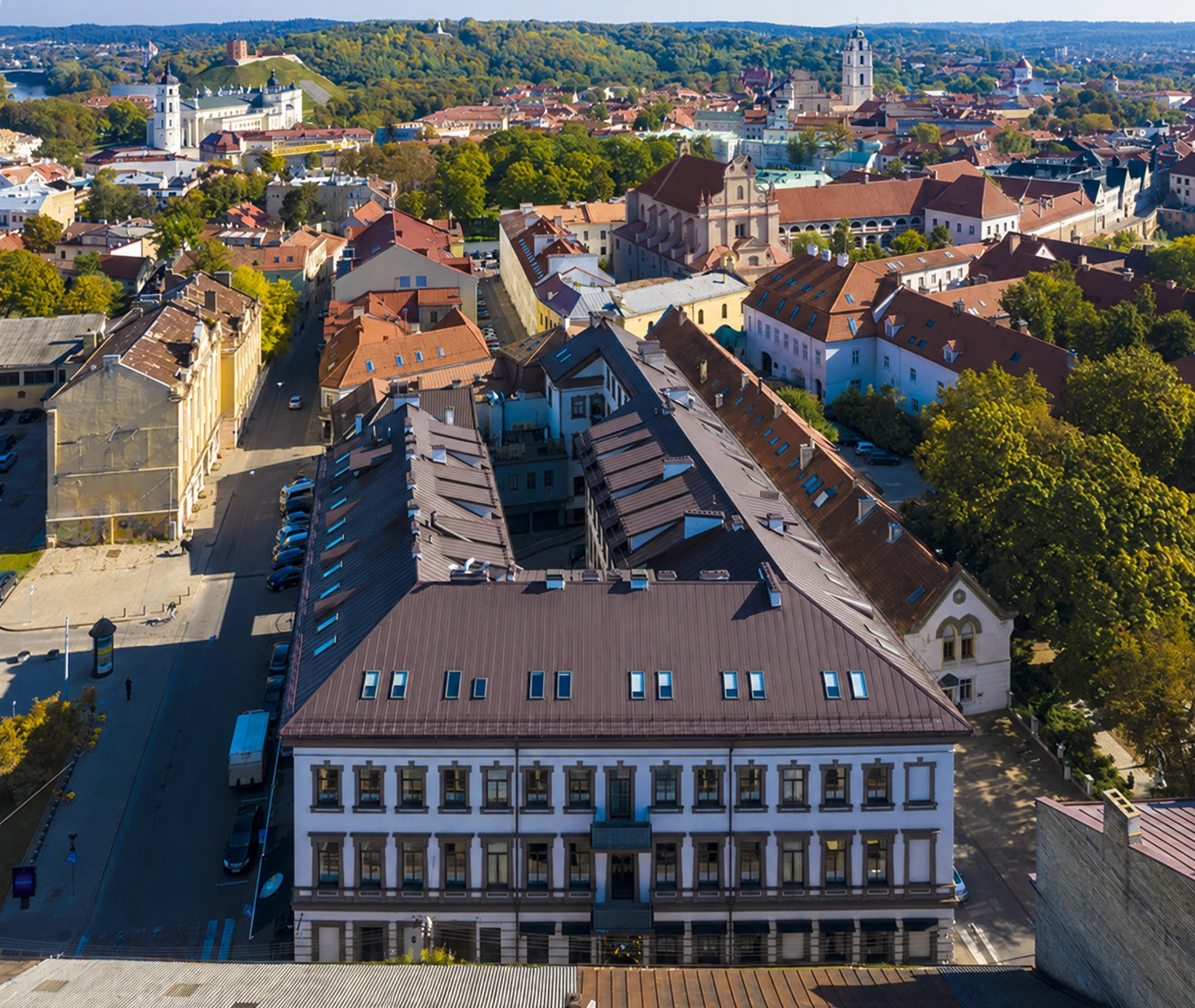 View of the old town from above, with building rooftops, an inner courtyard, and church towers visible in the distance.