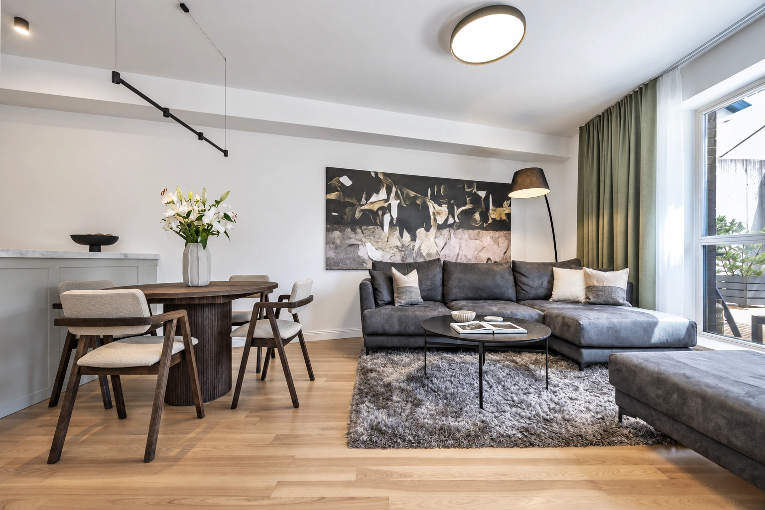 Im Wohnzimmer befinden sich ein Ecksofa und ein Esstisch mit Stühlen.