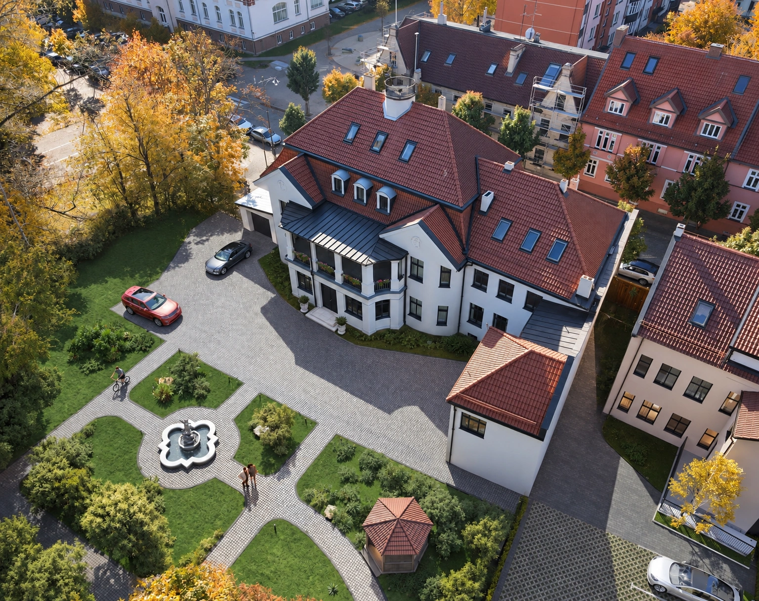 A residential building with a red roof and a landscaped yard, viewed from above.