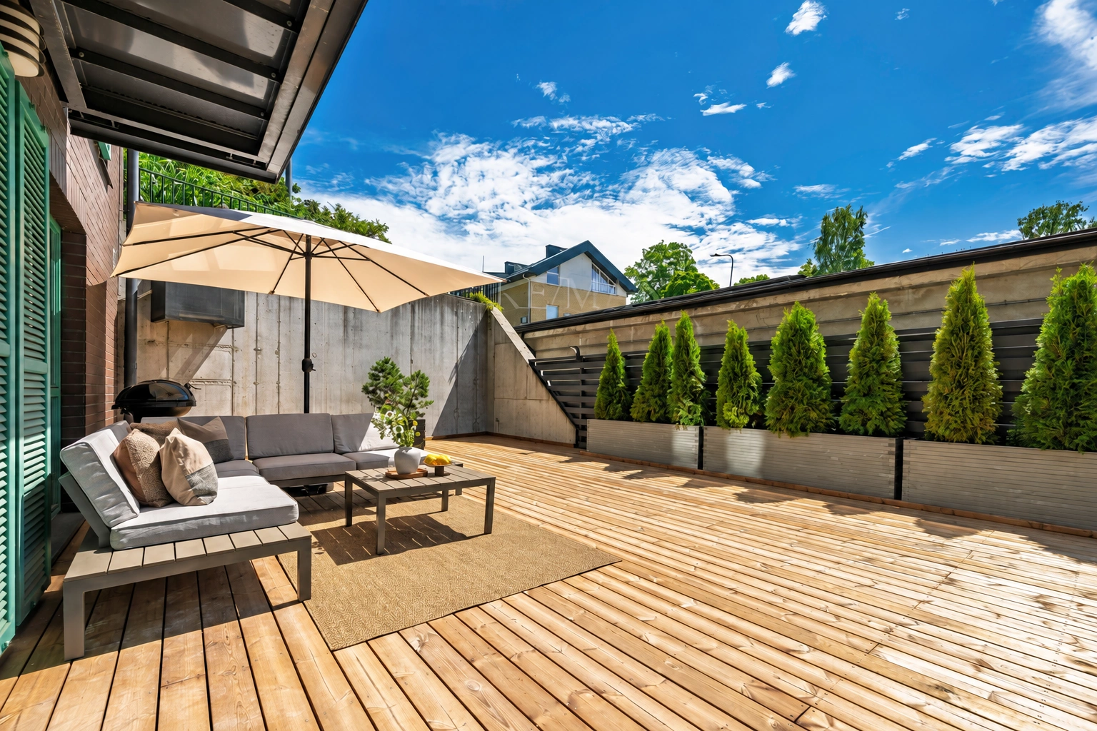 Terrasse mit Gartenmöbeln und einem Sonnenschirm.