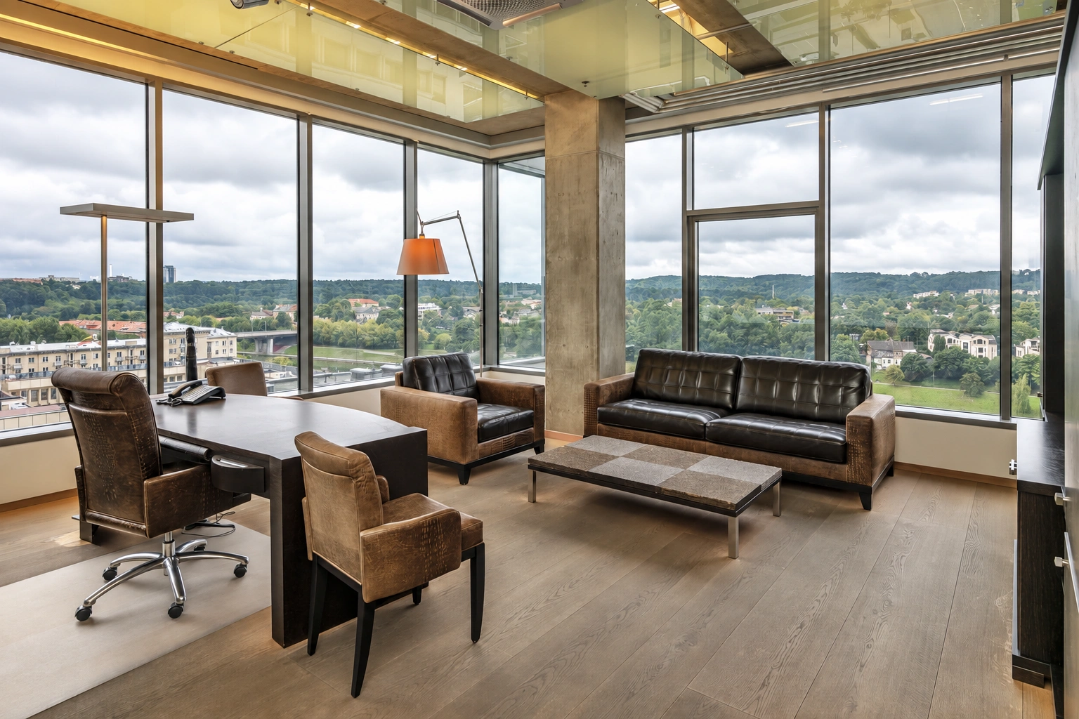 A room with large windows, sofas, and a small, low table in the center.