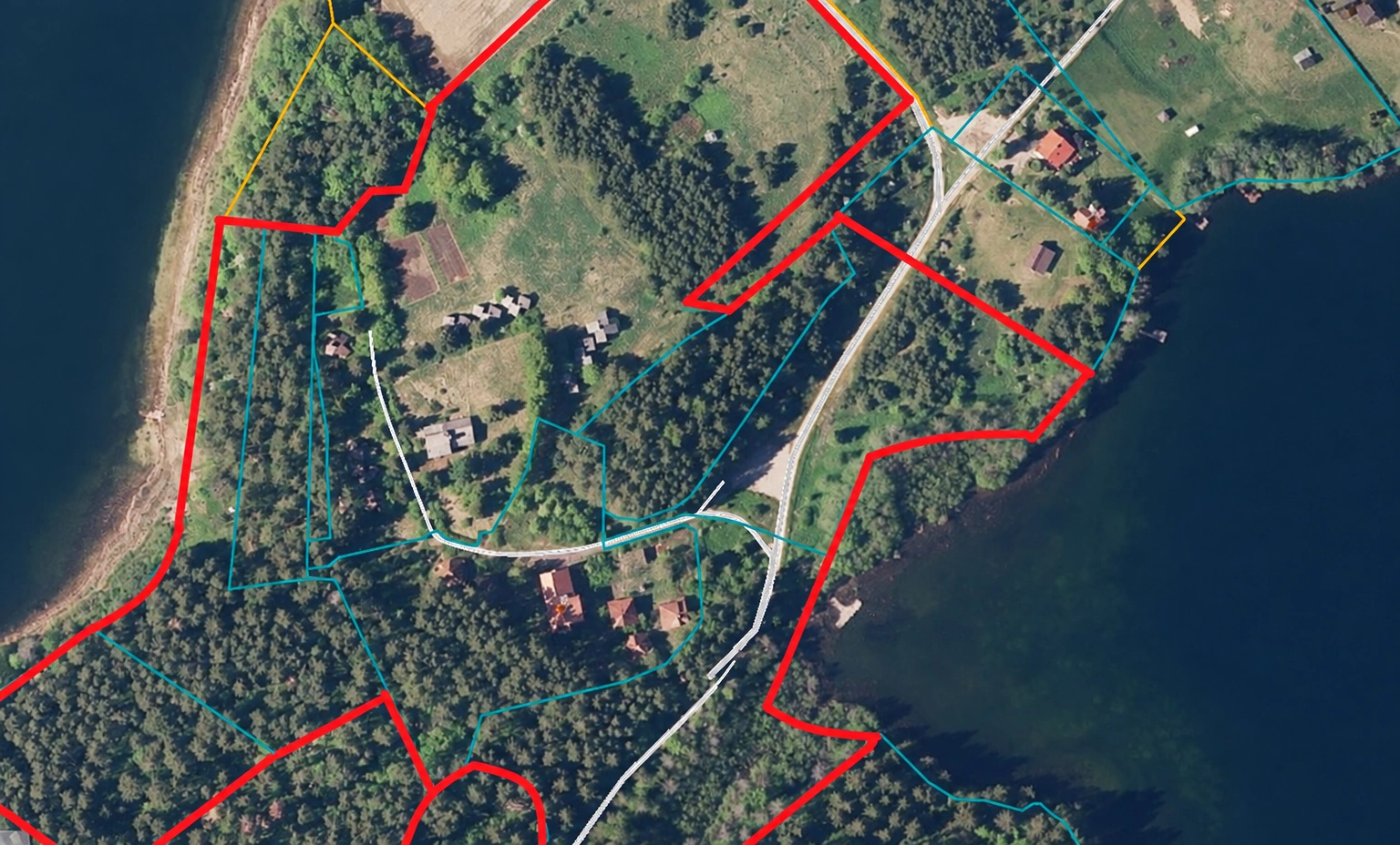 Luftaufnahme des Küstengebiets mit rot markierten Grenzen und einer Straße, die durch das Gebiet führt.