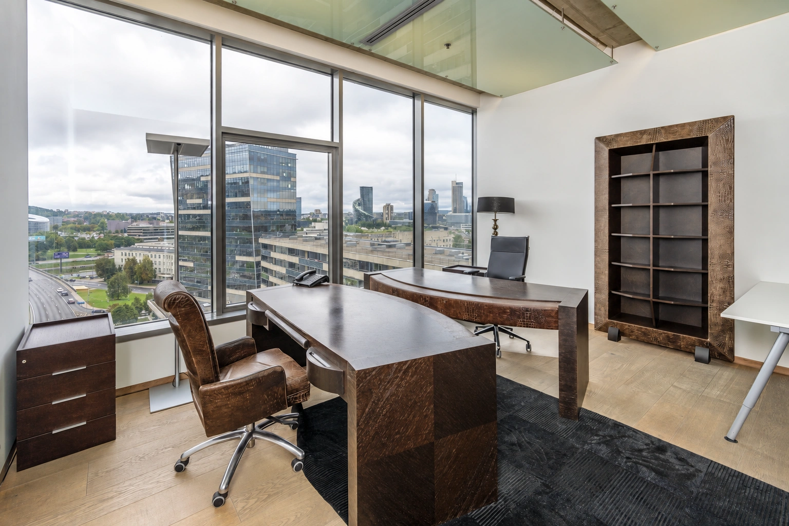 A study with large windows and two writing desks.
