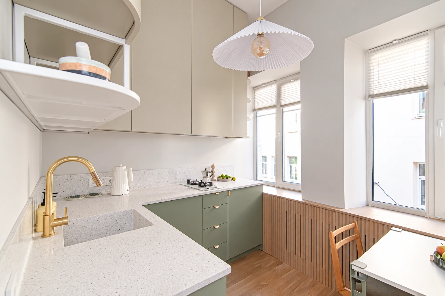 Kitchen with green lower cabinets and two large windows.