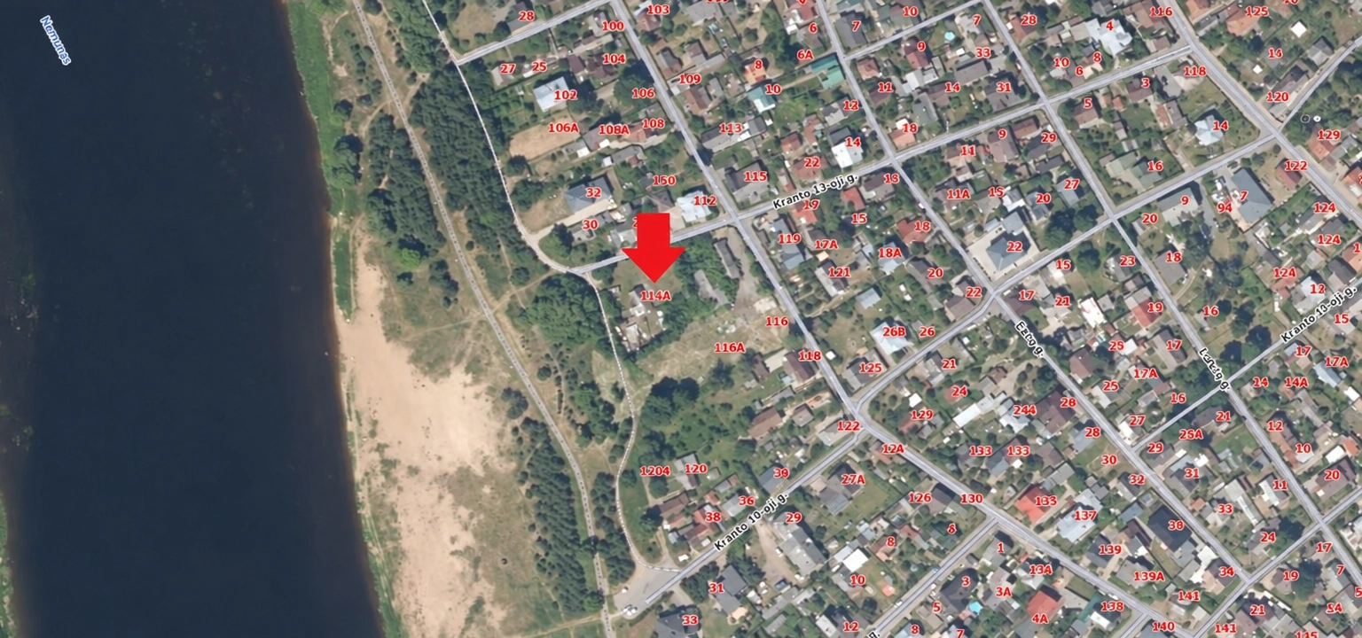 Aerial view of residential neighborhoods, a street network, and the shoreline of a body of water.