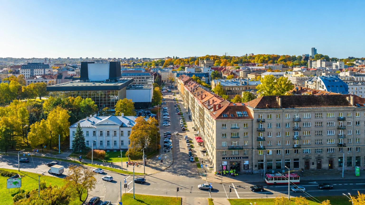 Blick auf die Stadt von oben mit Gebäuden, einer Straßenkreuzung und Bäumen.