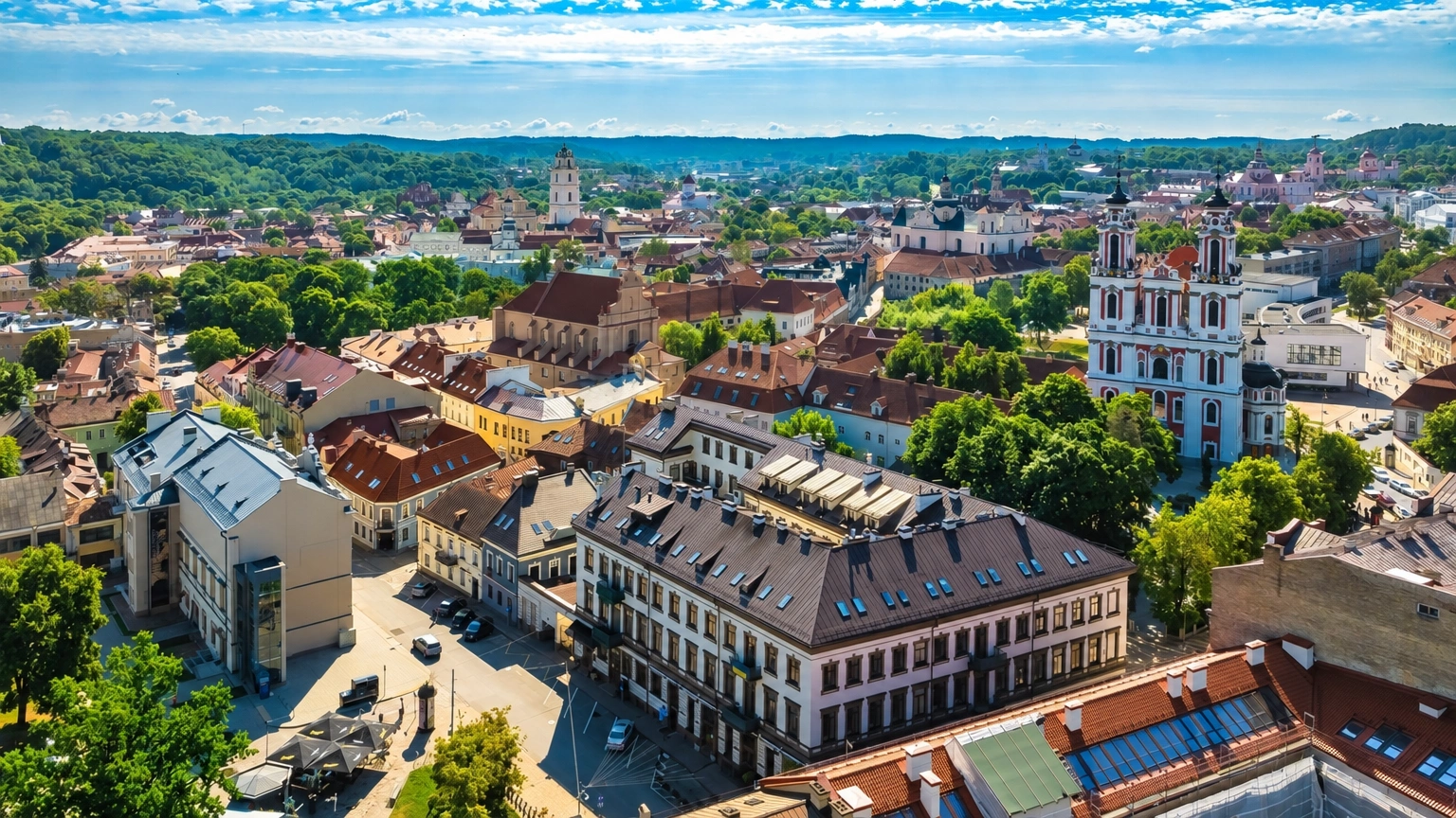 Stadtpanorama von oben mit Gebäudedächern und Kirchtürmen.