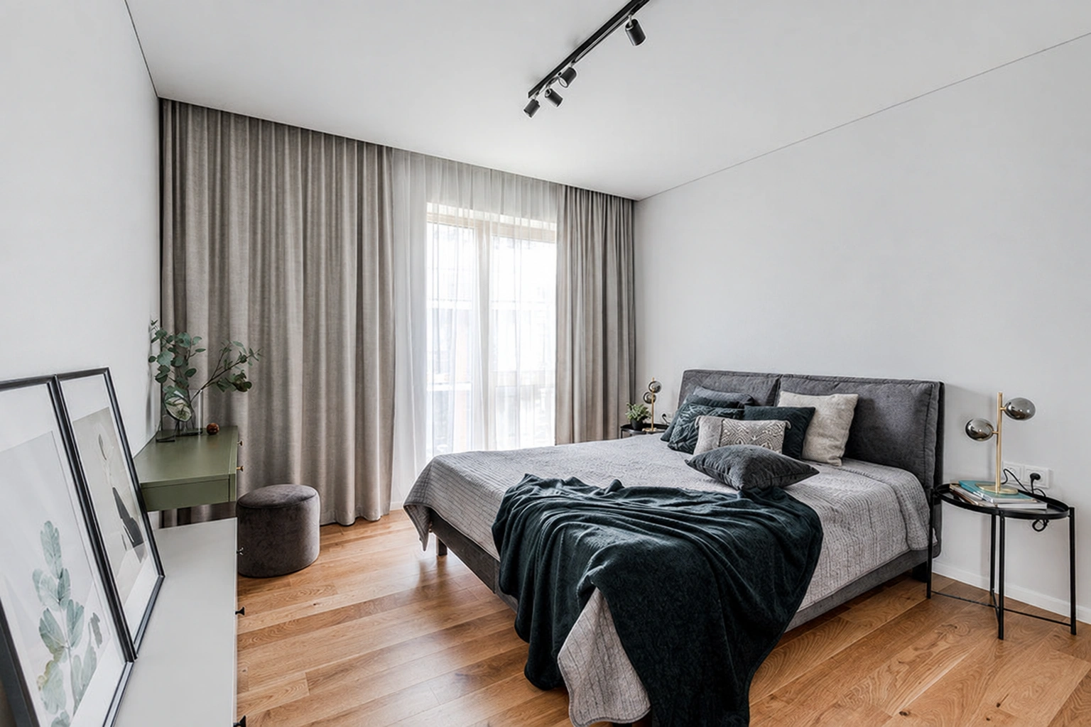 Schlafzimmer mit einem Doppelbett, einem großen Fenster, langen Vorhängen und einem Nachttisch.