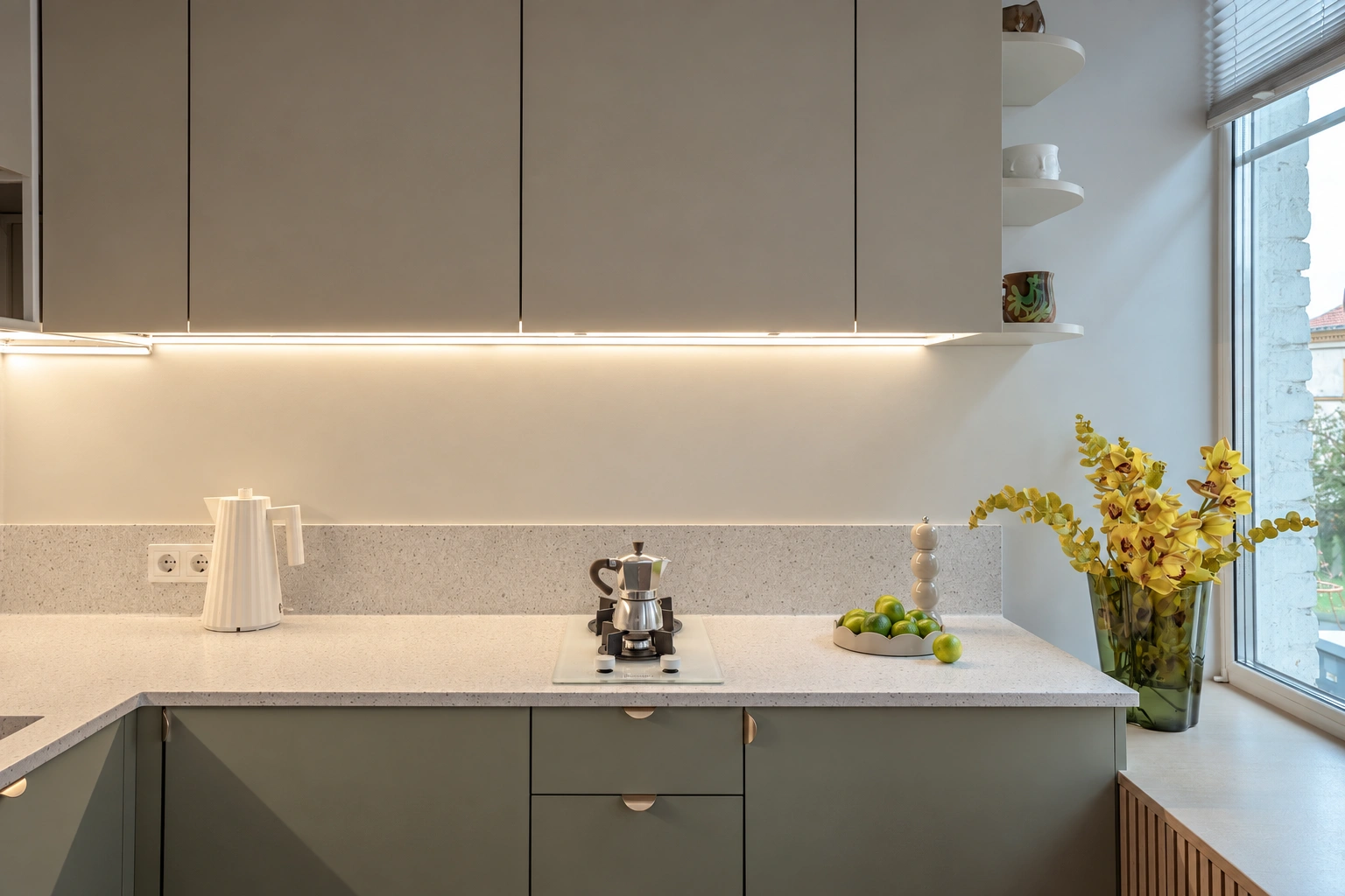 A kitchen with gray cabinets and an illuminated countertop beneath them.