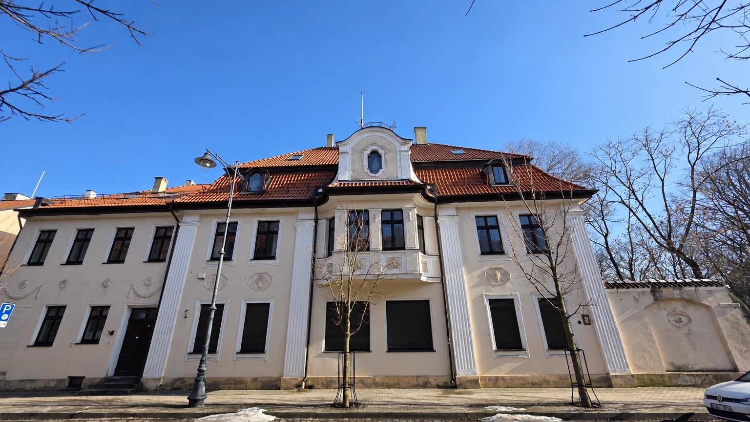 A two-storey building with a balcony and a pitched roof.