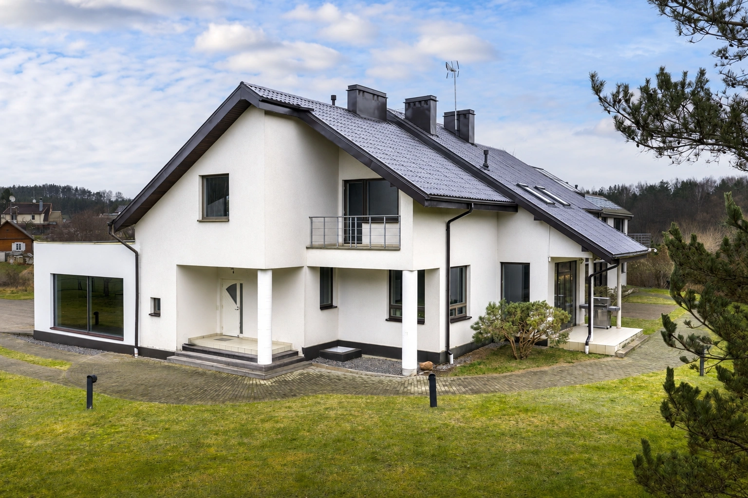 Ein zweistöckiges Haus mit einem Balkon und einer überdachten Terrasse.