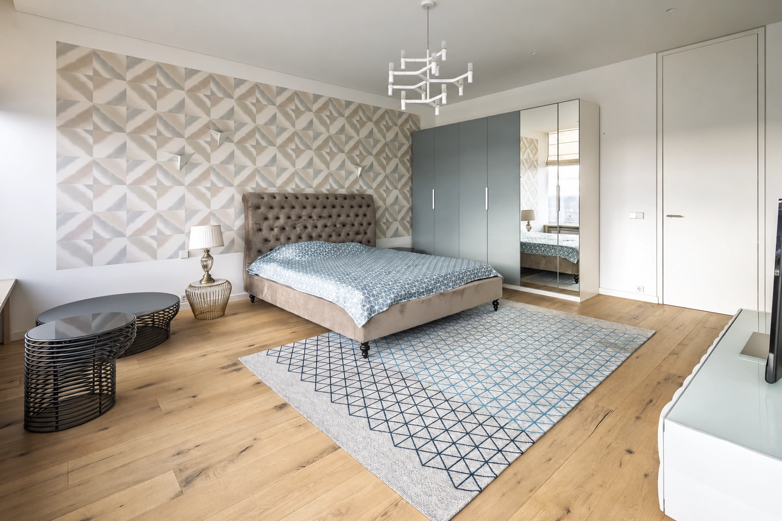 There is a double bed and a wardrobe with mirrored doors in the bedroom.