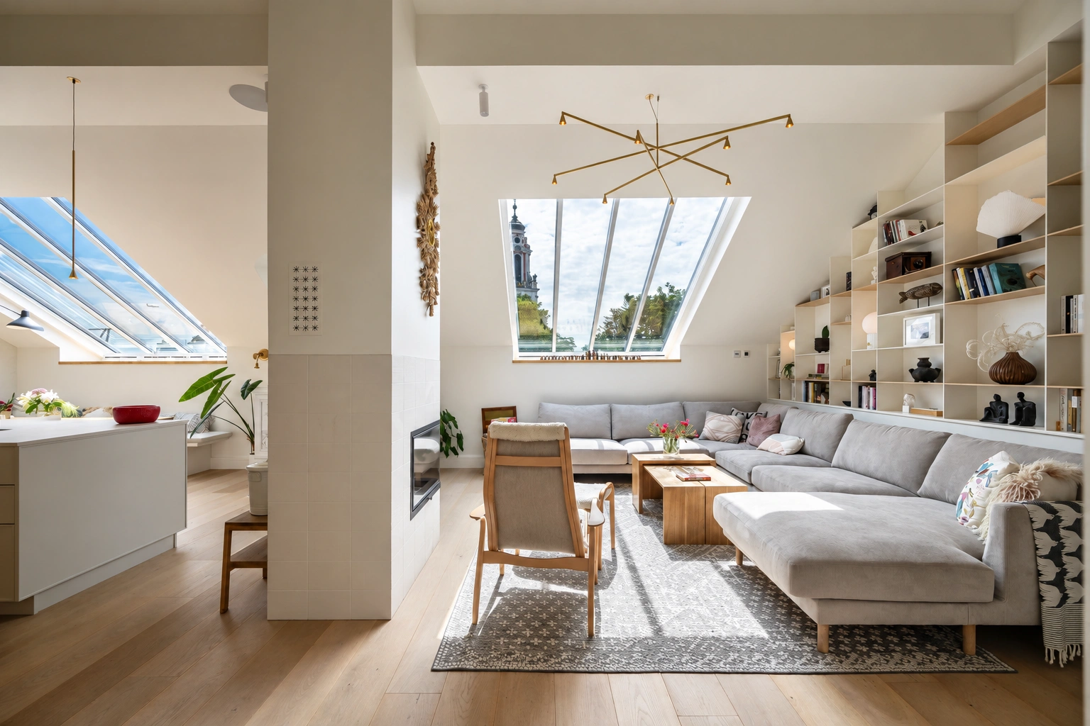 Wohnzimmer mit einem grauen Ecksofa, einem Couchtisch und einem großen Dachfenster.
