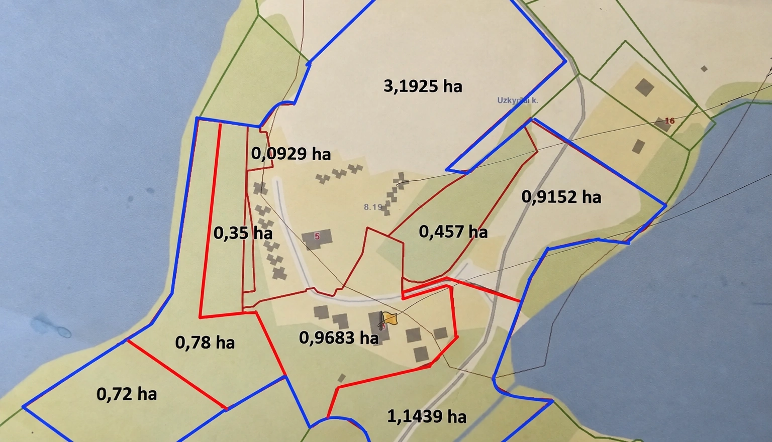 A plan of land plots with boundaries marked in color and areas indicated.