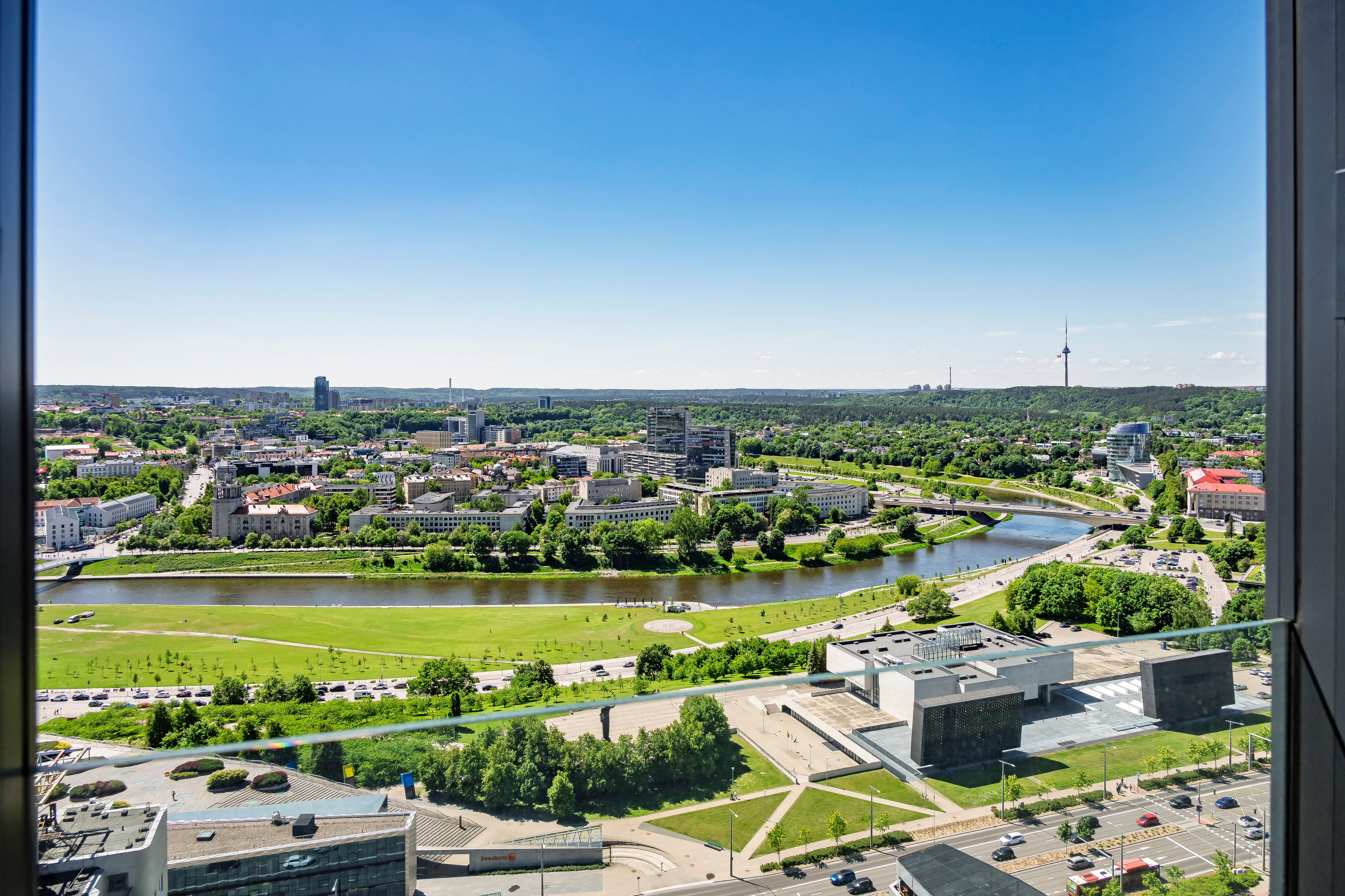 A city panorama with a river and a bridge can be seen through the window.