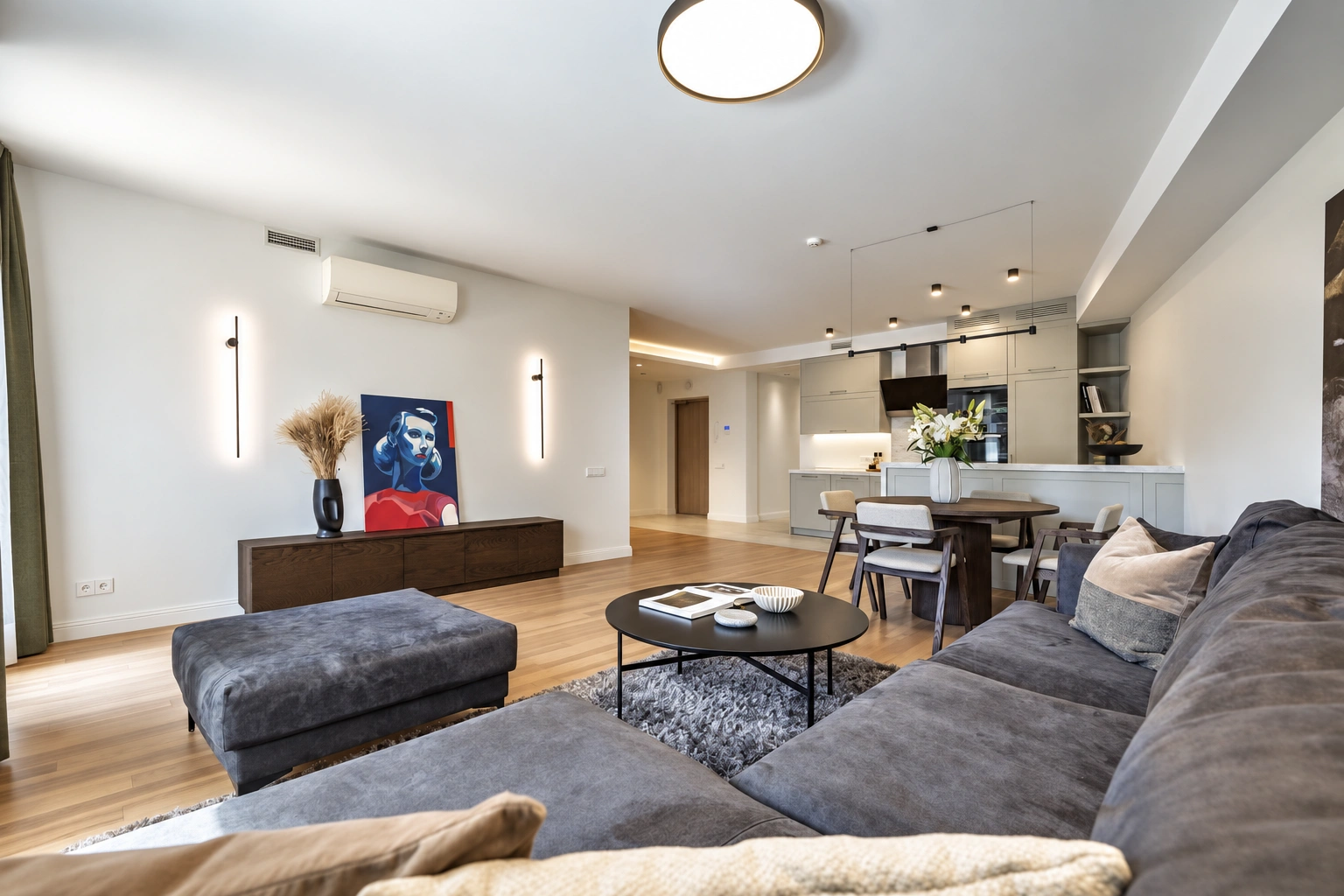 Wohnzimmer mit einem grauen Sofa und einem runden Couchtisch.
