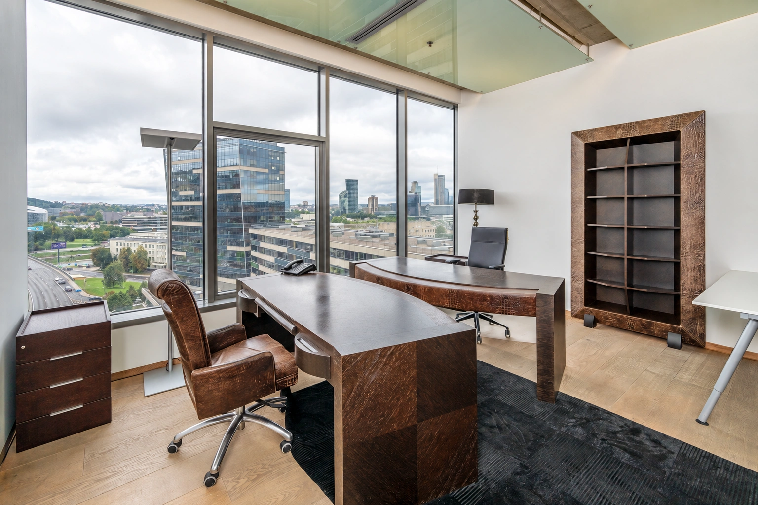 A desk, two chairs, and large windows can be seen in the study.