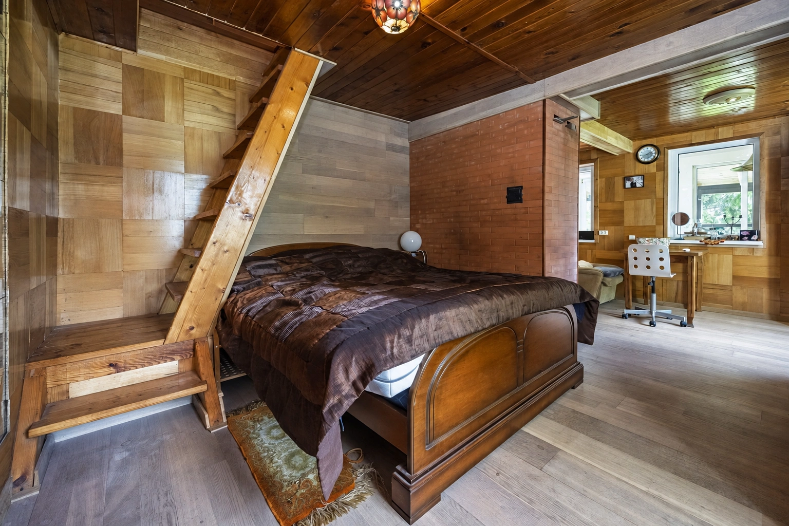 Bedroom with a double bed, a sloping ceiling and visible beams.