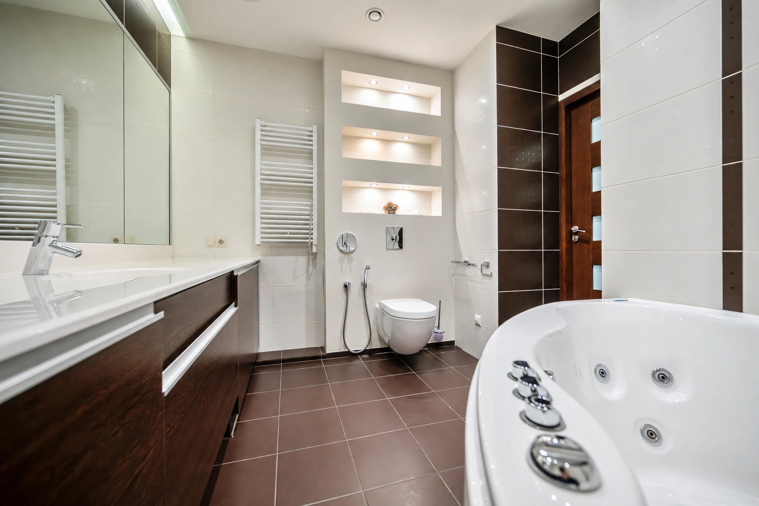 Badezimmer mit einer Badewanne auf der rechten Seite und einem Waschbecken unter einem breiten Wandspiegel.